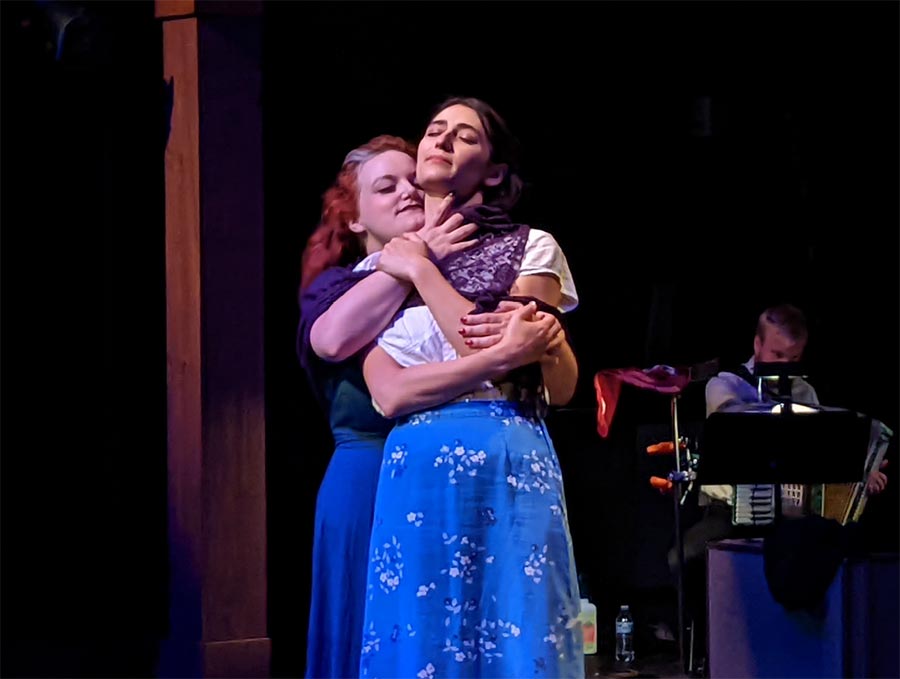 Two Women Holding Each Other on Stage